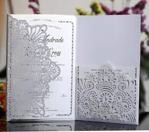 Macro detail of laser-cut floral mandala wedding invitation with pearl white finish