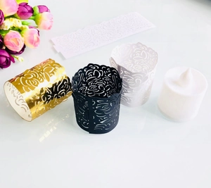 Detailed view of laser-cut paper tea light holders with intricate floral patterns in three colors