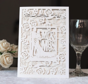Detail of laser cut wedding invitation with Mr & Mrs silhouette and rose patterns