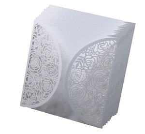 Detail of laser-cut white wedding invitation covers with intricate rose flower pattern
