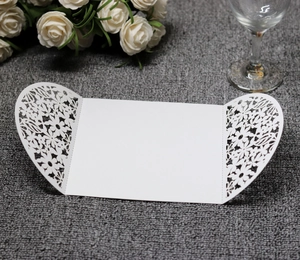 Detailed view of white laser-cut floral patterns on an elegant tri-fold wedding invitation