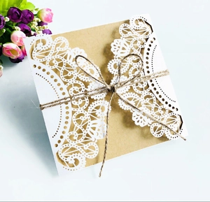 Detailed laser-cut lace pattern on white cardstock with kraft paper and twine bow