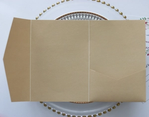 Detail of kraft paper wedding invitation with a three-fold design and internal pocket