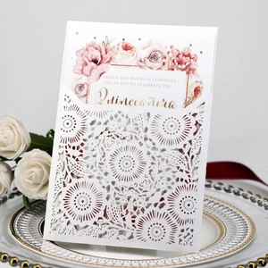 Macro detail of laser-cut floral wedding invitation with Quinceañera rose inner card