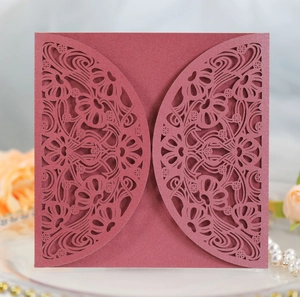 Intricate laser-cut floral pattern on burgundy pearlescent paper wedding invitation cover