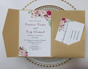 Detail of champagne gold invitation suite with floral inserts on a white beaded plate