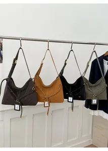 Detail showing four colors of retro hobo bags with woven rope accents and metal hardware