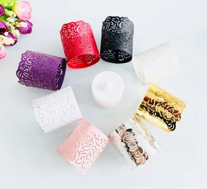 Overhead view of various colored laser-cut paper tea light wraps with floral patterns