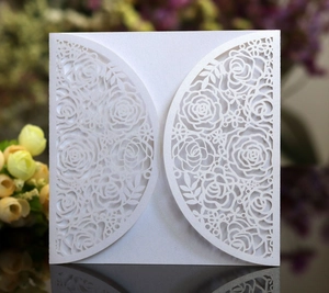 Detail of laser cut rose pattern on white pearlescent paper wedding invitation cover