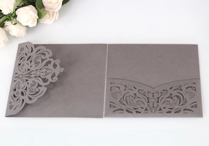 Macro view of laser-cut floral lace wedding invitation pocket in elegant dark grey