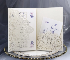 Detail of laser-cut ivory wedding invitation with intricate mandala floral patterns