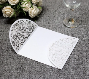 Detailed laser-cut white wedding invitation cover with intricate rose lace hollow design