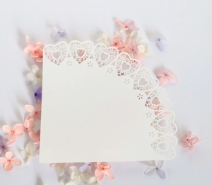 Detail of white laser-cut paper cone with delicate heart-shaped lace edges for weddings
