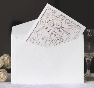 Detail of white laser-cut wedding invitation featuring Mr & Mrs silhouettes and floral motifs