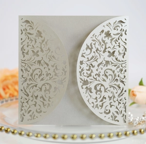 Macro detail of laser-cut floral patterns on pearlized champagne silver invitation cover