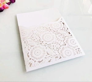Macro detail of elegant white laser-cut floral invitation cover with blank inner card insert