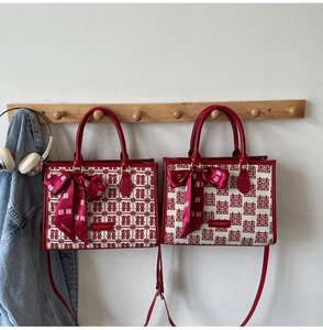 Detail of red wedding tote bags featuring festive double happiness patterns and bow charms