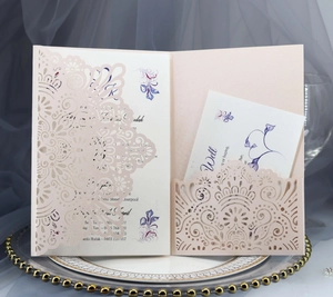 Close-up of laser-cut wedding invitation with elegant floral cards and ivory lace cover