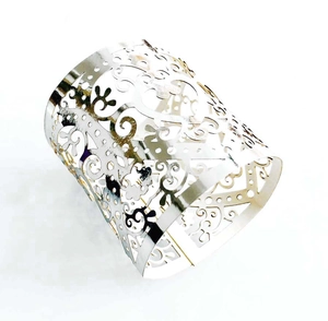 Macro detail of silver openwork metal bracelet with intricate filigree scroll patterns
