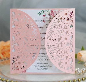 Pink laser-cut floral wedding invitation cover with white paper insert and elegant motifs