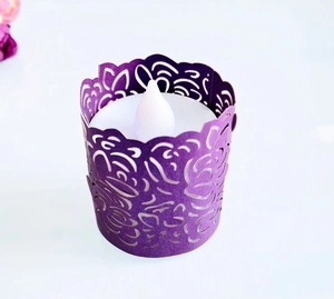 Detail of purple laser-cut paper candle wrap with floral pattern and internal LED tea light