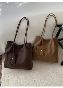 Detail of matte leather tote bags in coffee and camel with matching mini pouch sets
