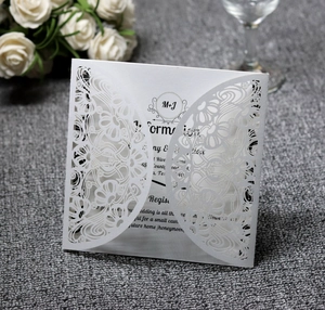 Macro view of laser-cut lace floral pattern on elegant white wedding invitation cover