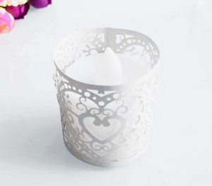 Top view of white laser-cut hollow paper lampshade with heart patterns and LED tea light