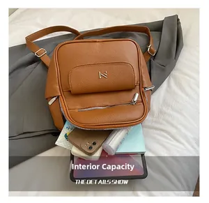 Internal capacity of brown leather backpack showing space for tablet and phone