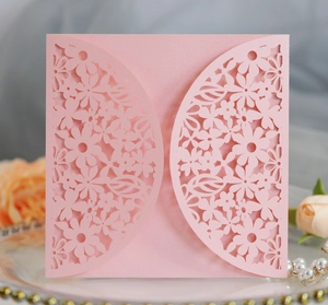 Detail of pink laser-cut floral wedding invitation card with elegant pearlescent finish