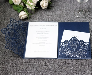 Detail of laser-cut navy blue lace wedding invitation with elegant hollow patterns