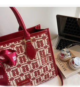 Detail of red bridal tote bag with double happiness jacquard and silk ribbon decoration