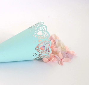 Detail of laser-cut heart pattern on blue wedding petal cone with dried flowers
