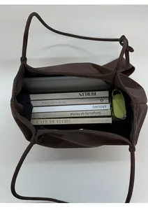 Top view of large brown leather tote bag interior showing ample space for books and umbrella
