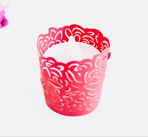 Detail of red hollow laser-cut rose pattern paper wrap with LED tealight candle