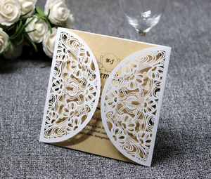 Macro detail of laser-cut floral wedding invitation with white cover and kraft insert