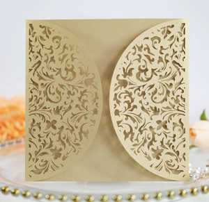 Macro detail of champagne gold laser-cut floral pattern on elegant wedding invitation