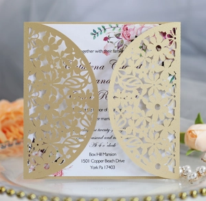 Close-up of laser cut hollow floral wedding invitation with pink rose inner card