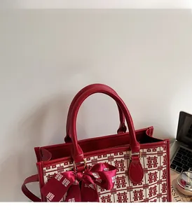 Detail of red wedding tote bag with traditional double happiness logo and silk bow knot