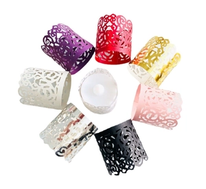 Laser-cut paper tea light wraps with intricate floral vine patterns in multiple colors