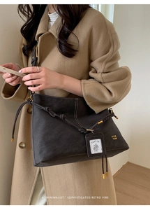 Macro view of retro dark gray tote bag with visible white stitching and minimalist card holder