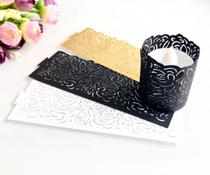 Detailed laser cut paper wraps with floral patterns in gold black and white for LED candles