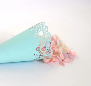 Detailed laser cut heart pattern on a light blue wedding petal cone with dry flowers