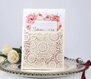 Laser-cut floral wedding invitation with Quinceañera gold text on elegant ceramic plate