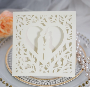 Detailed laser cut wedding invitation card featuring cream heart and couple silhouette