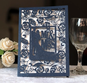 Detail of laser-cut navy blue glitter wedding card with hollow floral and silhouette patterns