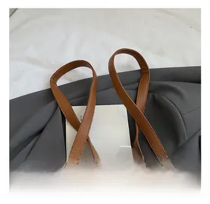 Close-up of brown lychee texture leather backpack with adjustable straps and metal zippers
