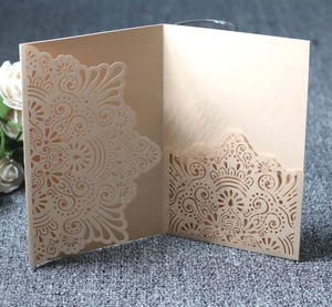Detailed laser-cut champagne gold hollow wedding invitation with intricate floral patterns
