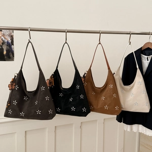 Détail de sacs fourre-tout évidés avec accents floraux et breloques perlées en quatre couleurs
