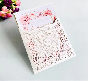 Macro shot of laser-cut burgundy wedding invitation with elegant floral inner card
